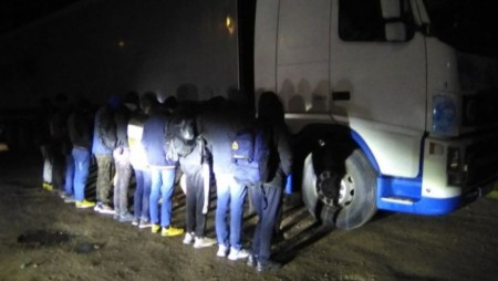 Задържаха шофьор на камион и 11 бежанци в тайник